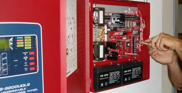 fire alarm installation service showing technician configuring fire alarm control panel in Denver, CO