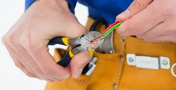 licensed electrician securing electrical wiring with professional tools during service work in Denver, CO